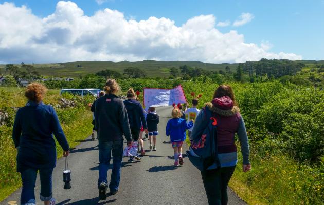 Image of community members walking along a road on Raasay