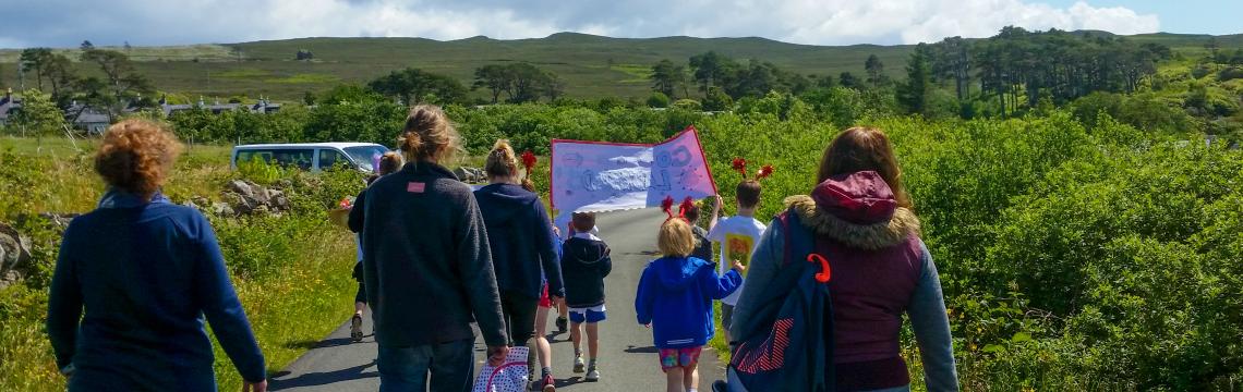 Image of community members walking along a road on Raasay