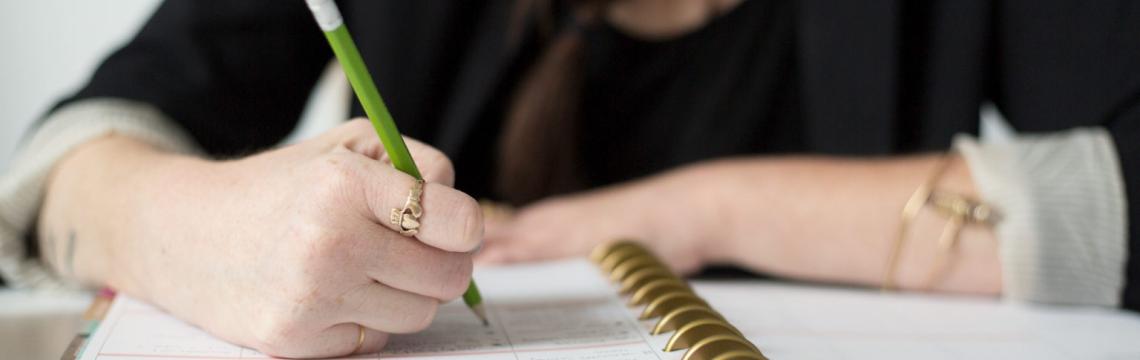 Photo of someone writing in a notebook