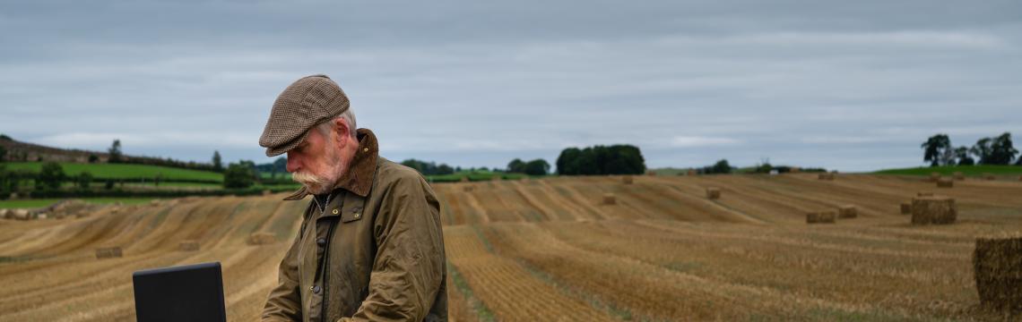 Man in field with laptop